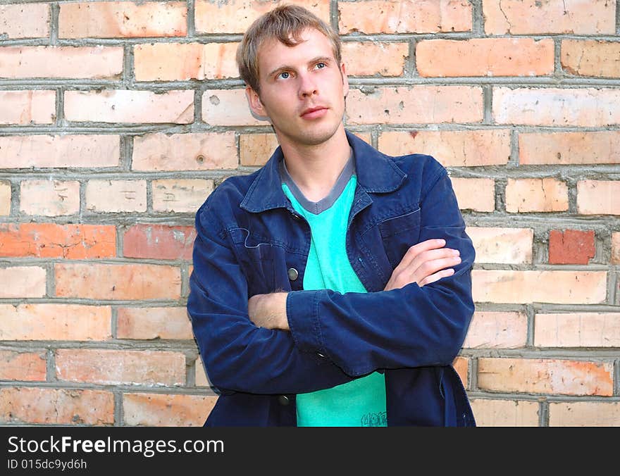 Young stylish man stand near brick wall.