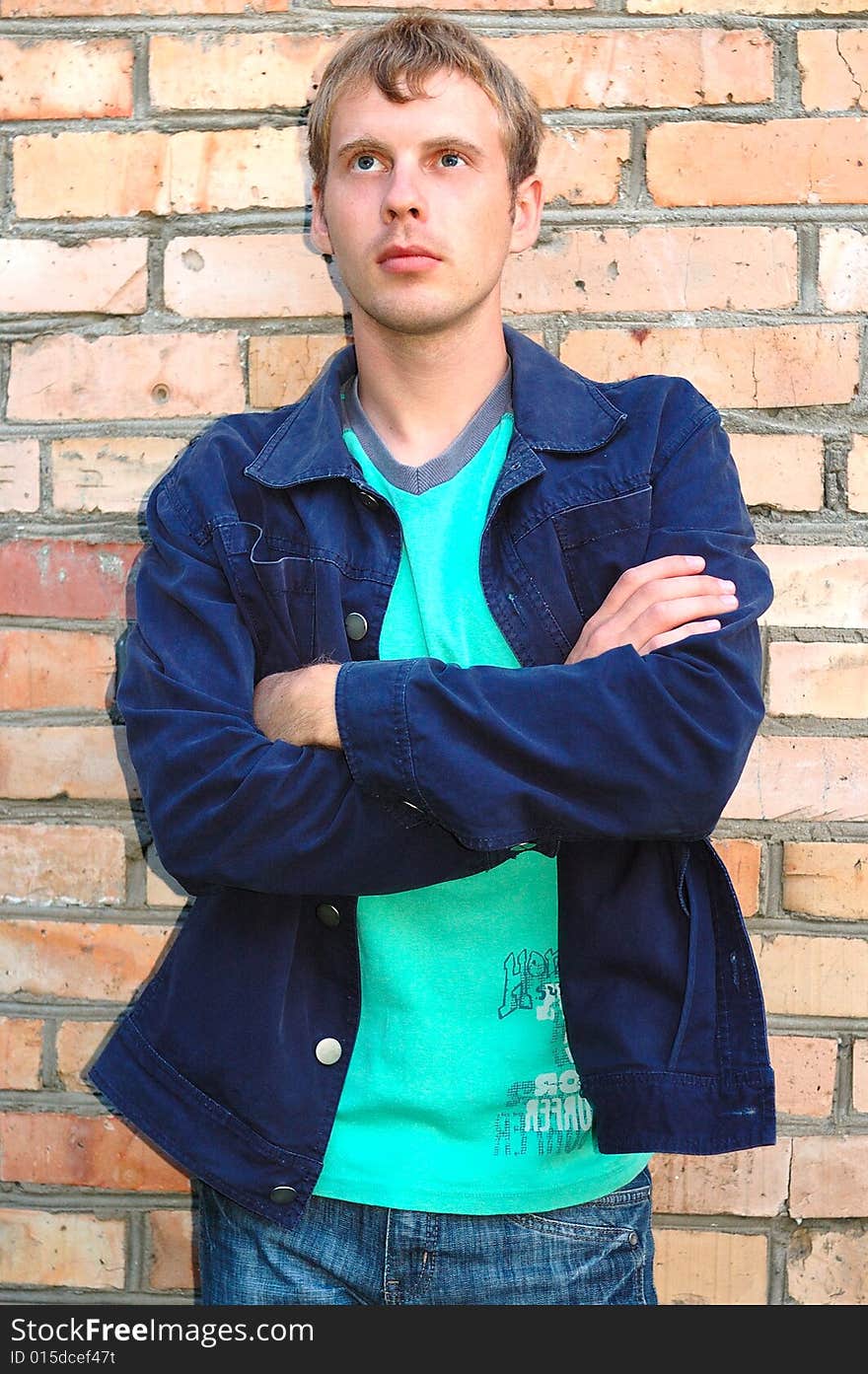 Young stylish man stand near brick wall.