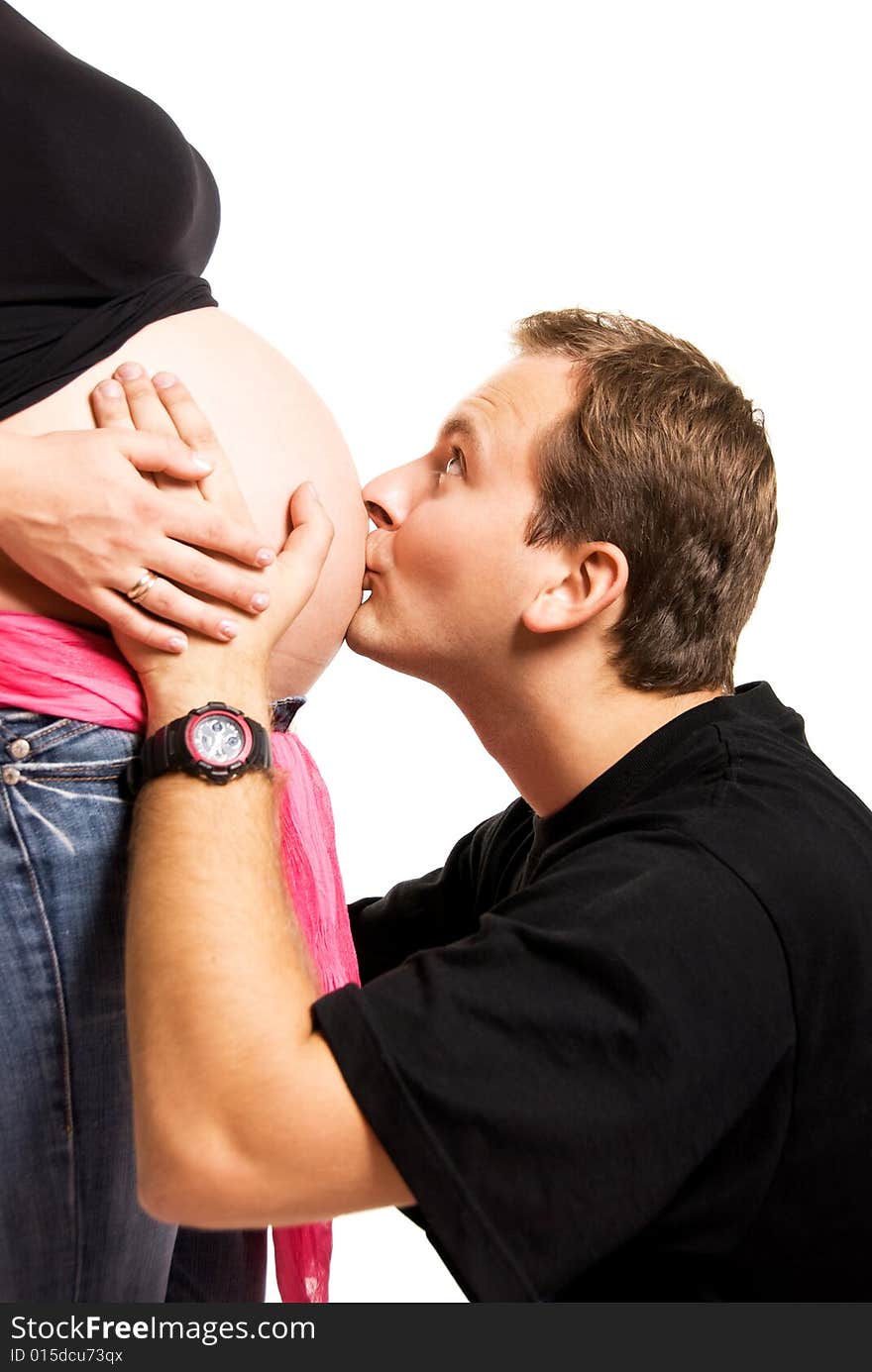 Father kissing the belly of his pregnant wife. Father kissing the belly of his pregnant wife