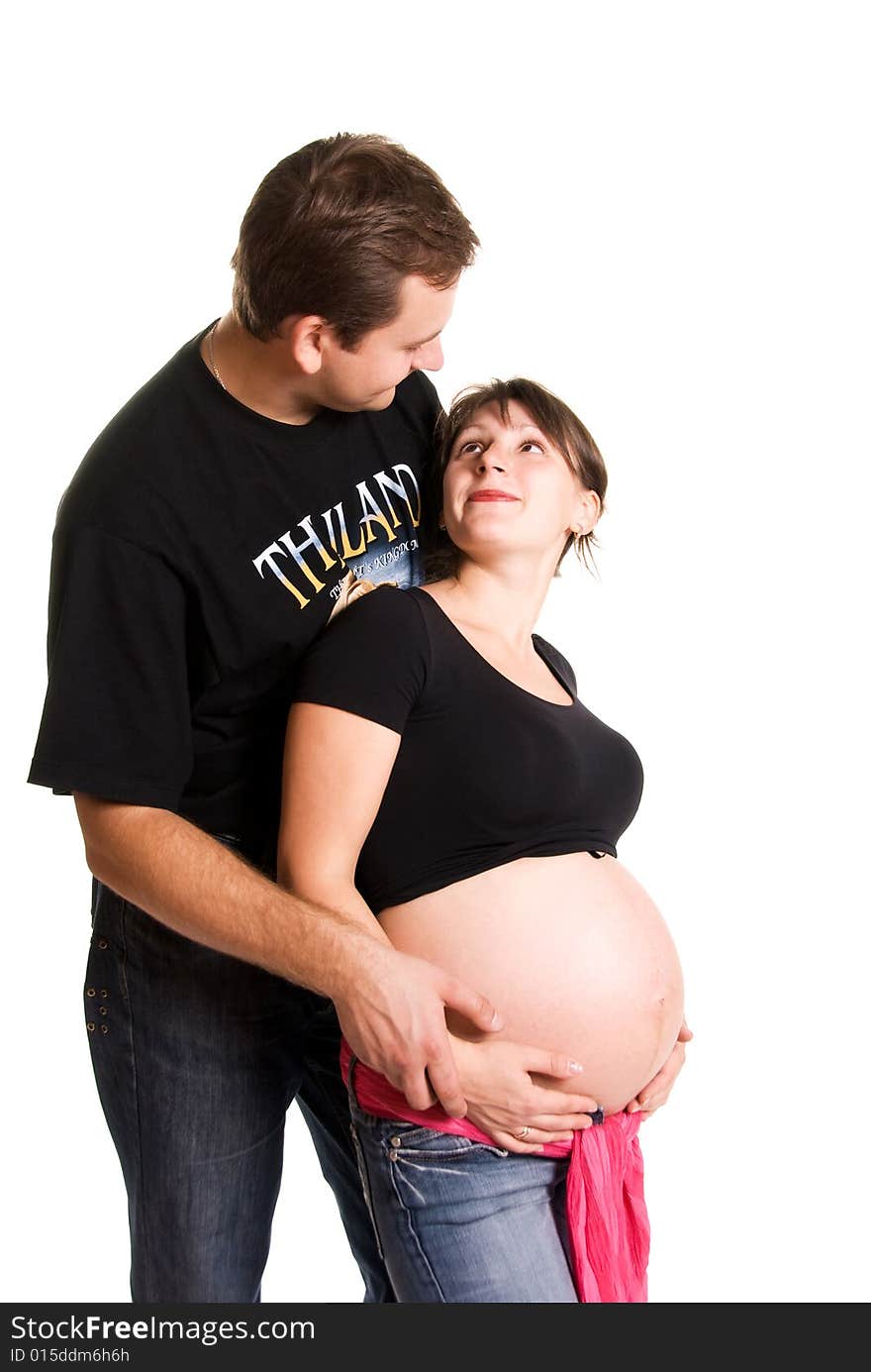 Pregnant woman and her husband embracing and looking at each other. Pregnant woman and her husband embracing and looking at each other