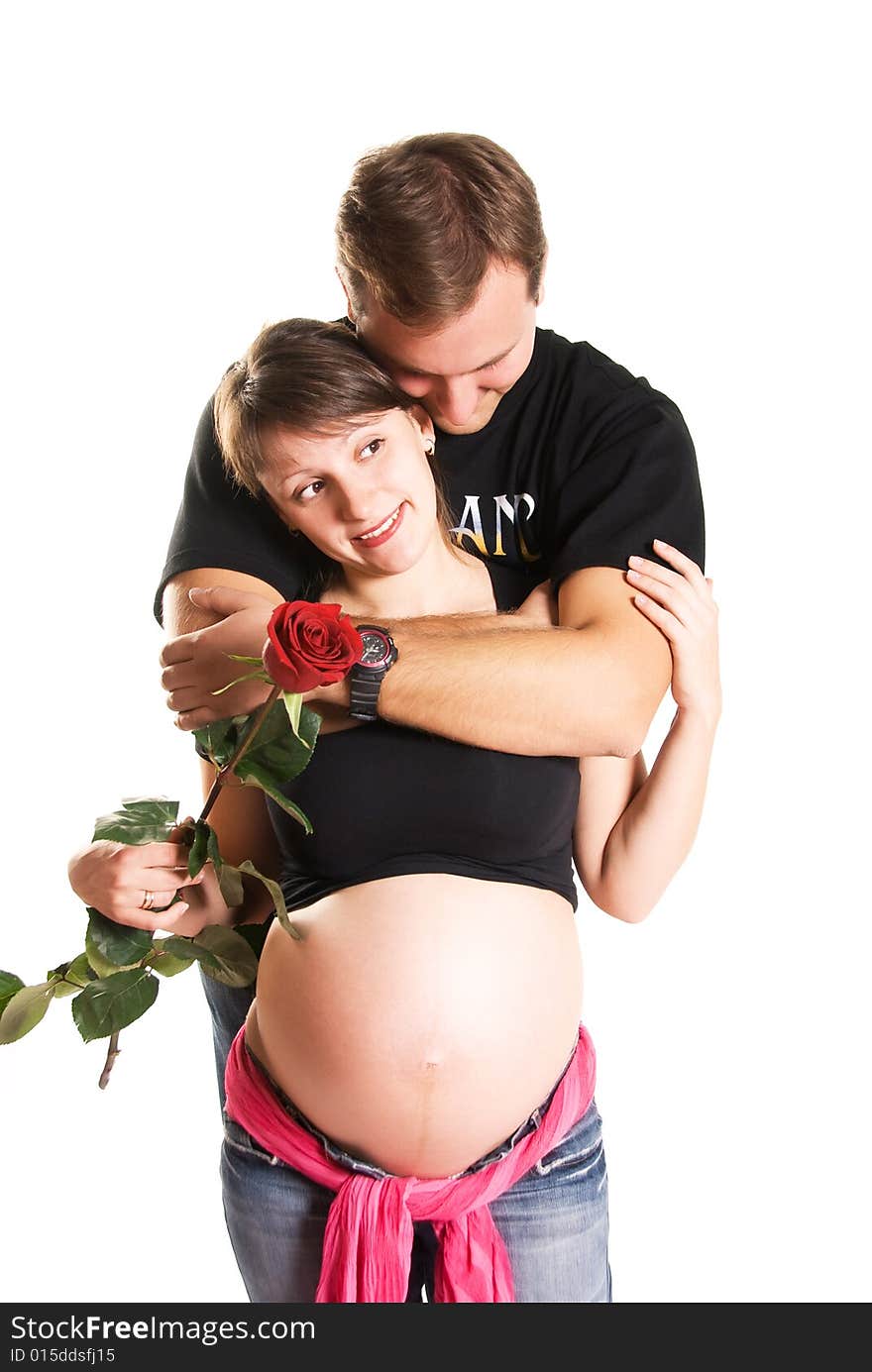 Pregnant woman holding a rose and her husband isolated against white background. Pregnant woman holding a rose and her husband isolated against white background