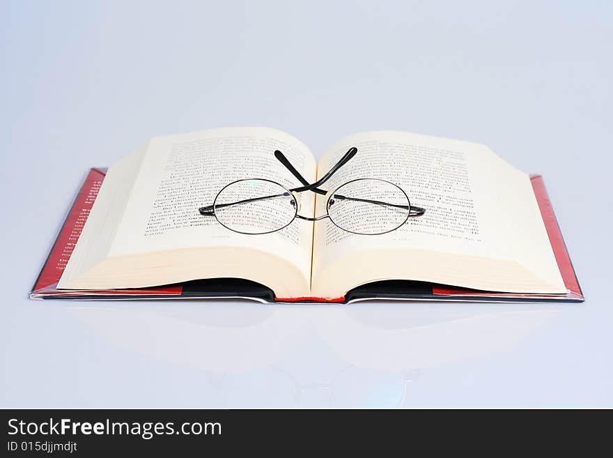 Open book with a pair of eye glasses on top