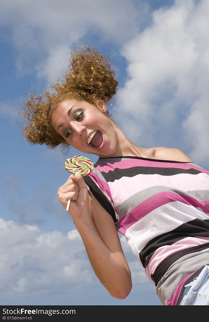 Fun blonde girl with lollipop in clouds