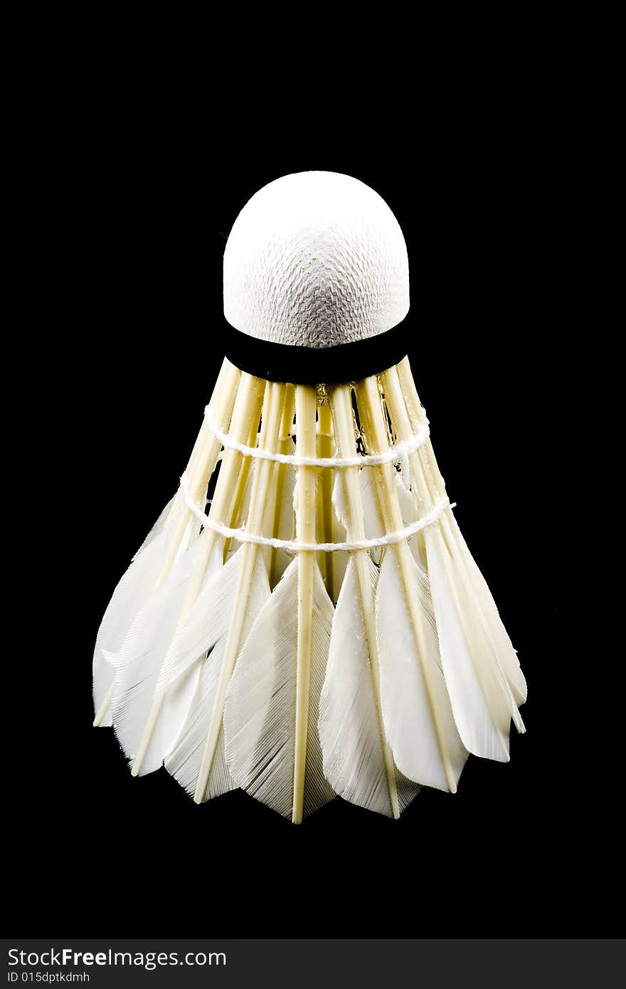 A white shuttlecock with feathers on the black background