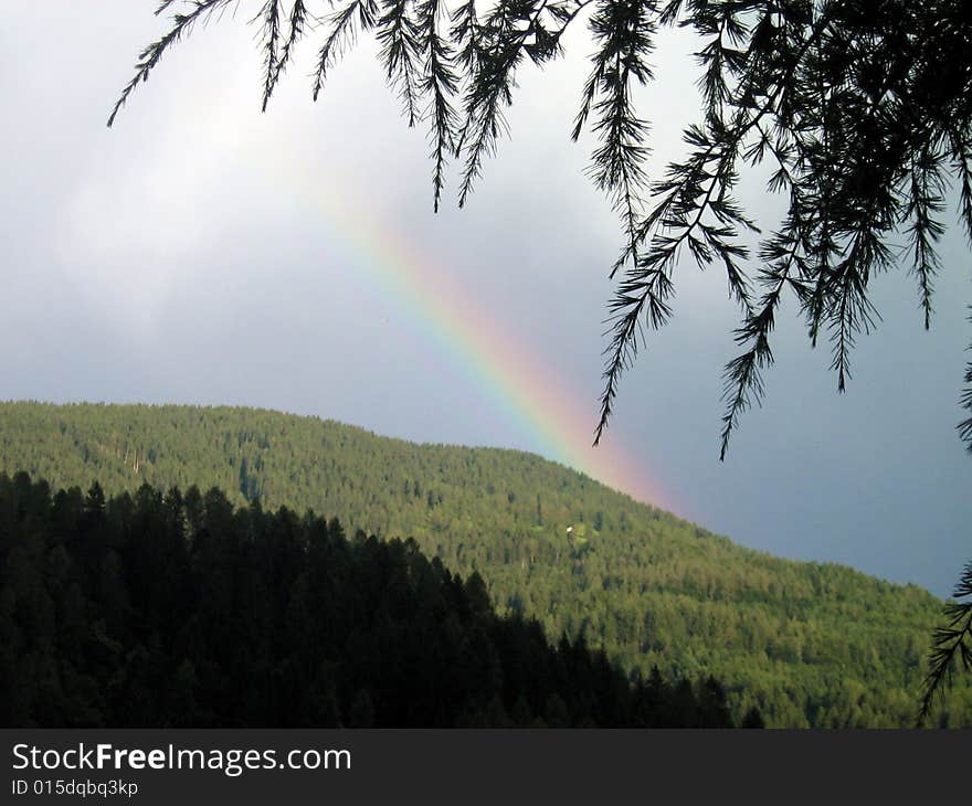 Pretty rainbow on the mountains with trees