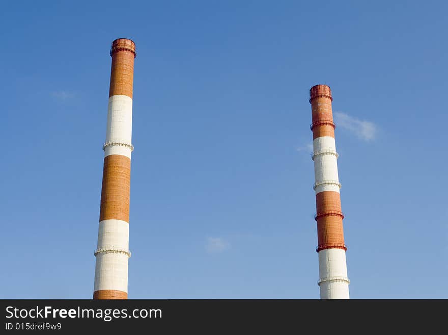 Two Red and white pipes on blue sky