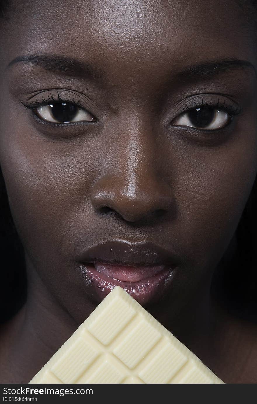 Portrait of a black woman eating a bar of choccolate. Portrait of a black woman eating a bar of choccolate