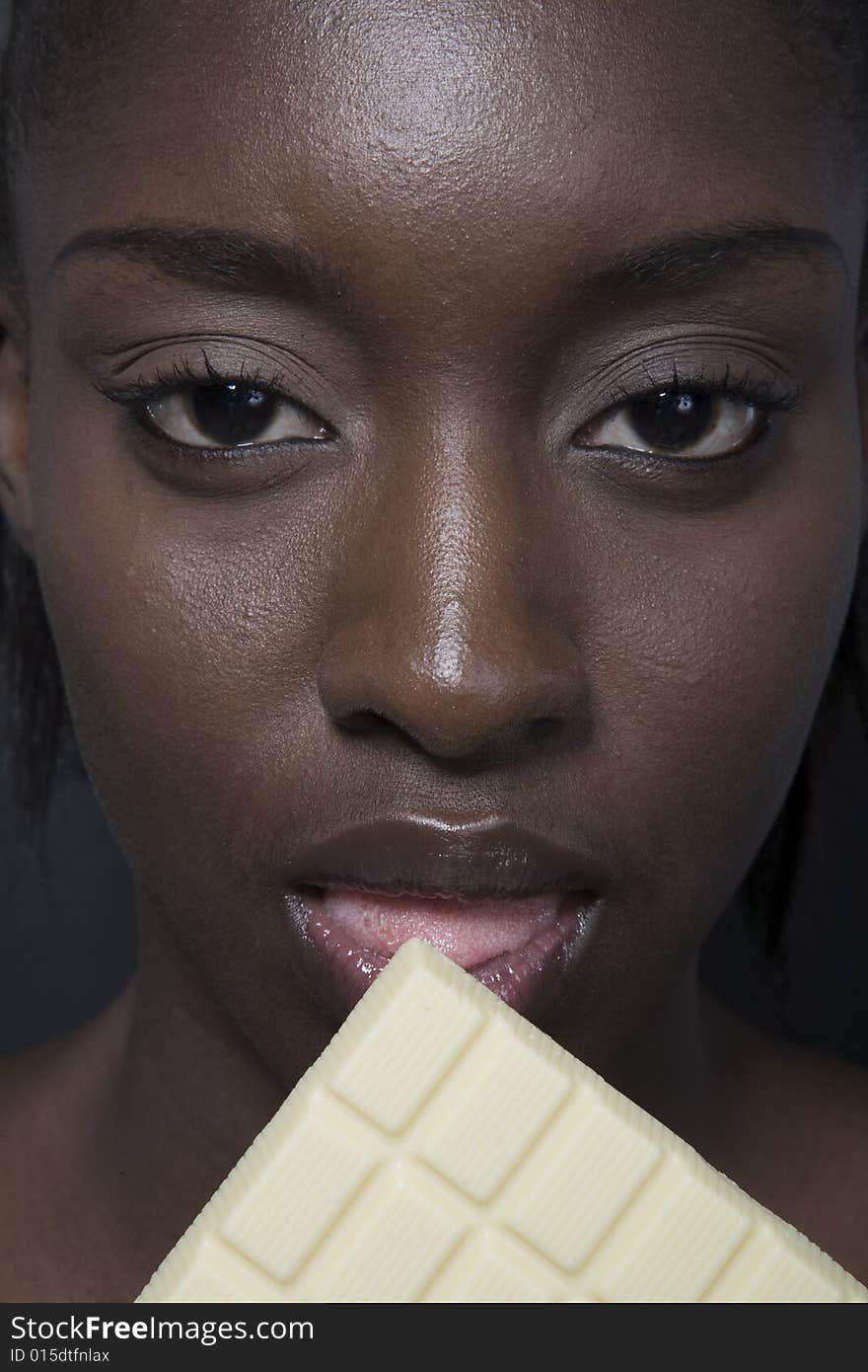 Portrait of a black woman eating a bar of choccolate. Portrait of a black woman eating a bar of choccolate