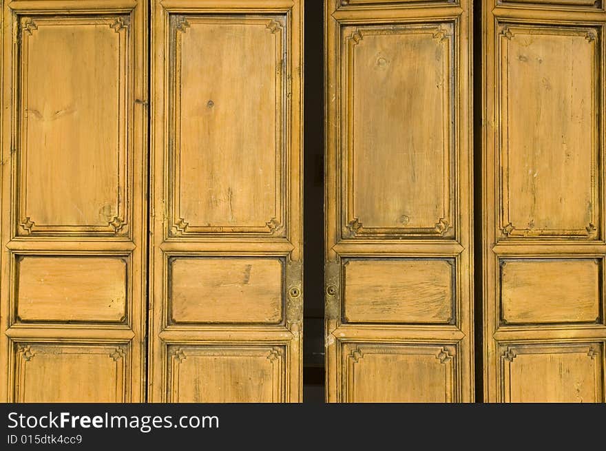 Ancient, wooden door painted in yellow color, house in Shangrila, Yunnan province, China.