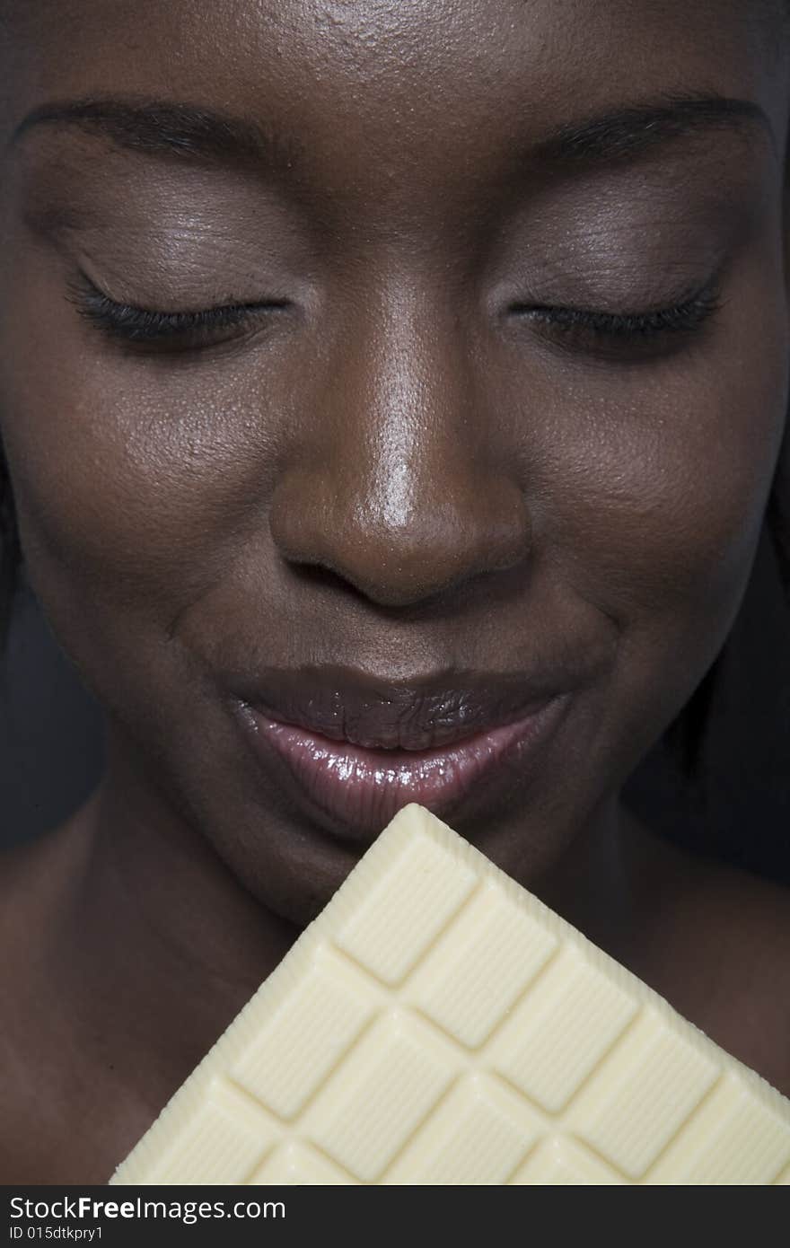 Portrait of a black woman eating a bar of choccolate. Portrait of a black woman eating a bar of choccolate