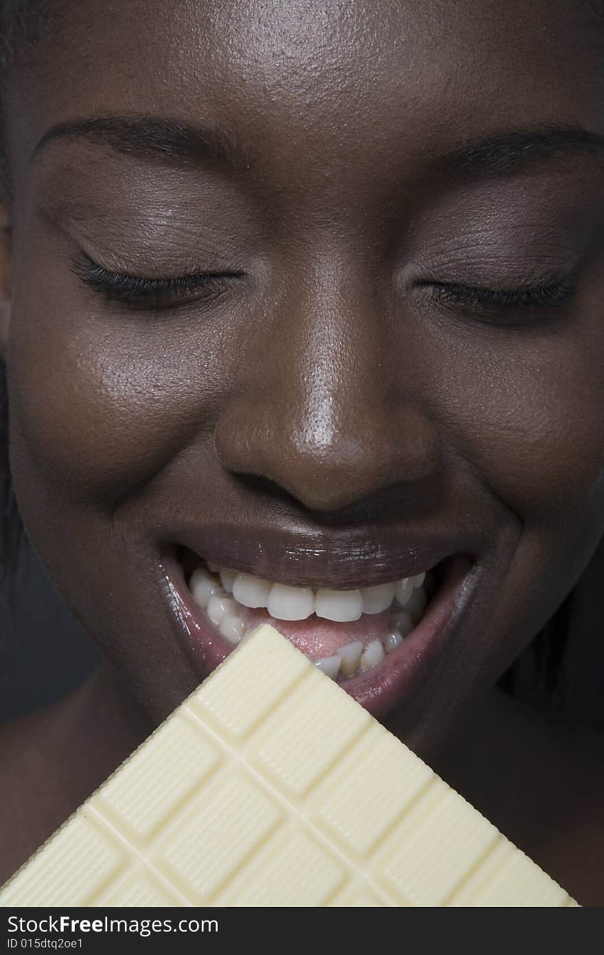 Portrait of a black woman eating a bar of choccolate. Portrait of a black woman eating a bar of choccolate