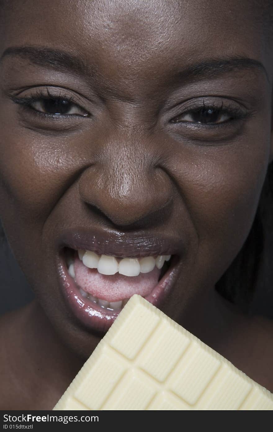 Portrait of a black woman eating a bar of choccolate. Portrait of a black woman eating a bar of choccolate