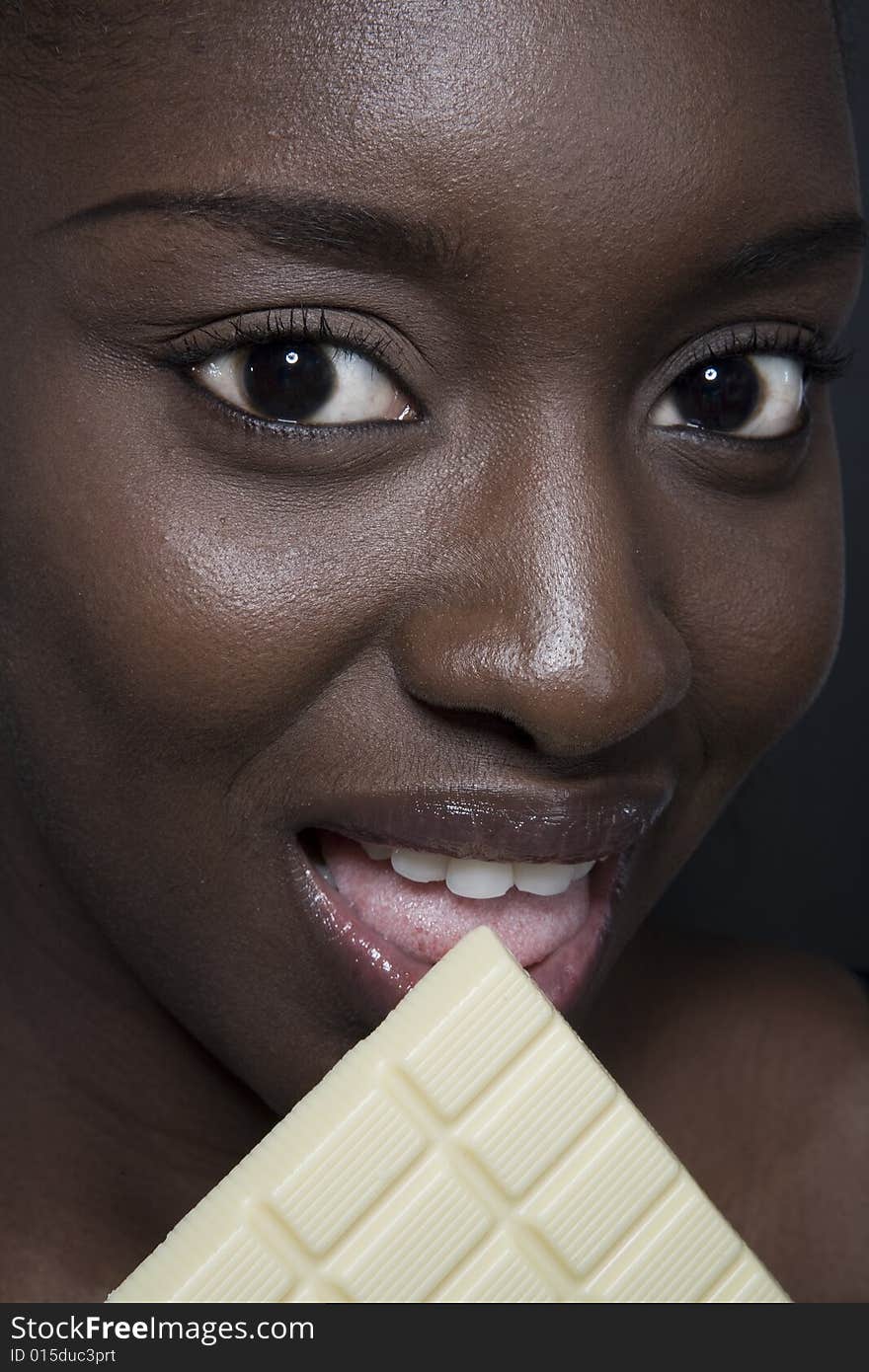 Portrait of a black woman eating a bar of choccolate. Portrait of a black woman eating a bar of choccolate