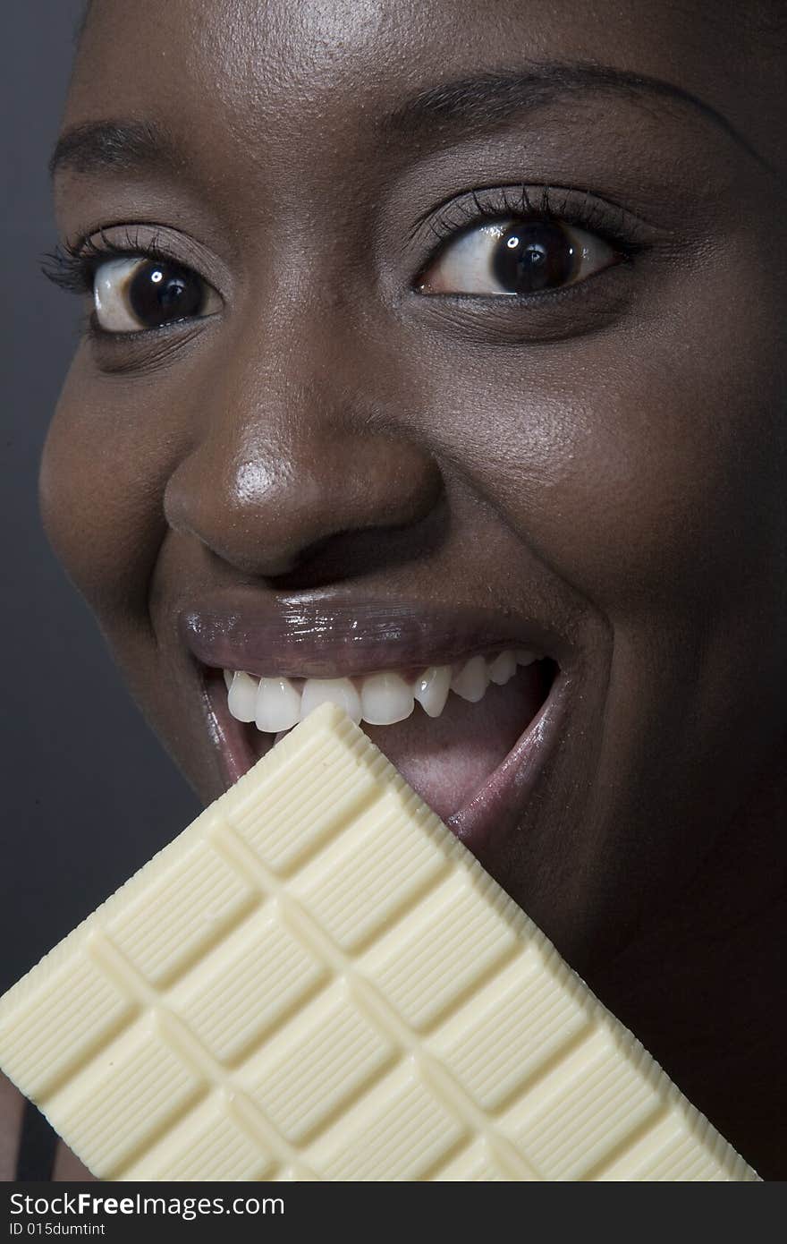 Portrait of a black woman eating a bar of choccolate. Portrait of a black woman eating a bar of choccolate