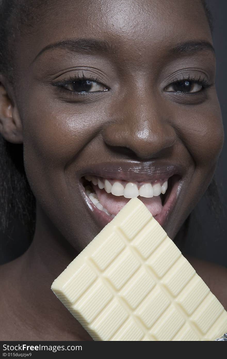 Portrait of a black woman eating a bar of choccolate. Portrait of a black woman eating a bar of choccolate