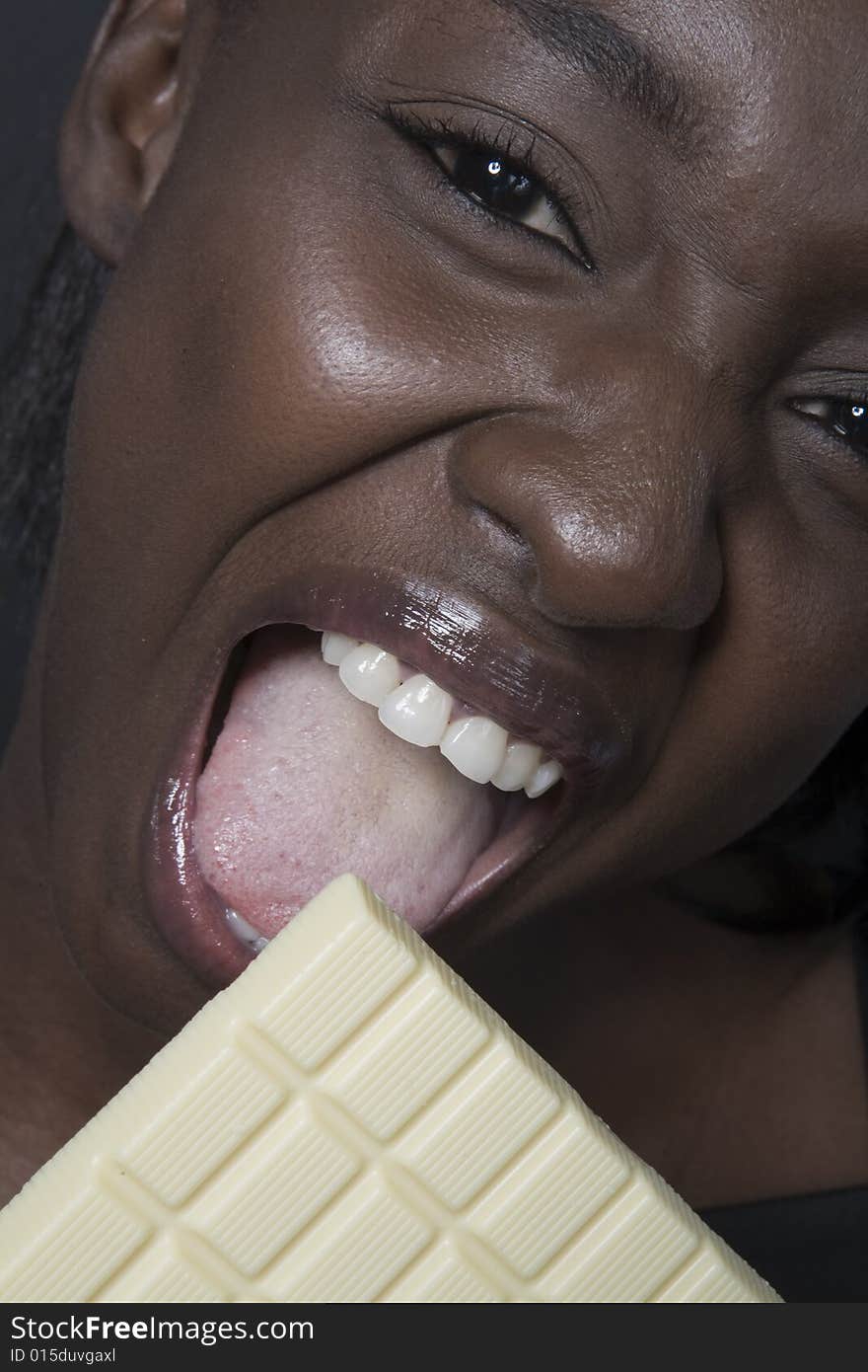 Portrait of a black woman eating a bar of choccolate. Portrait of a black woman eating a bar of choccolate