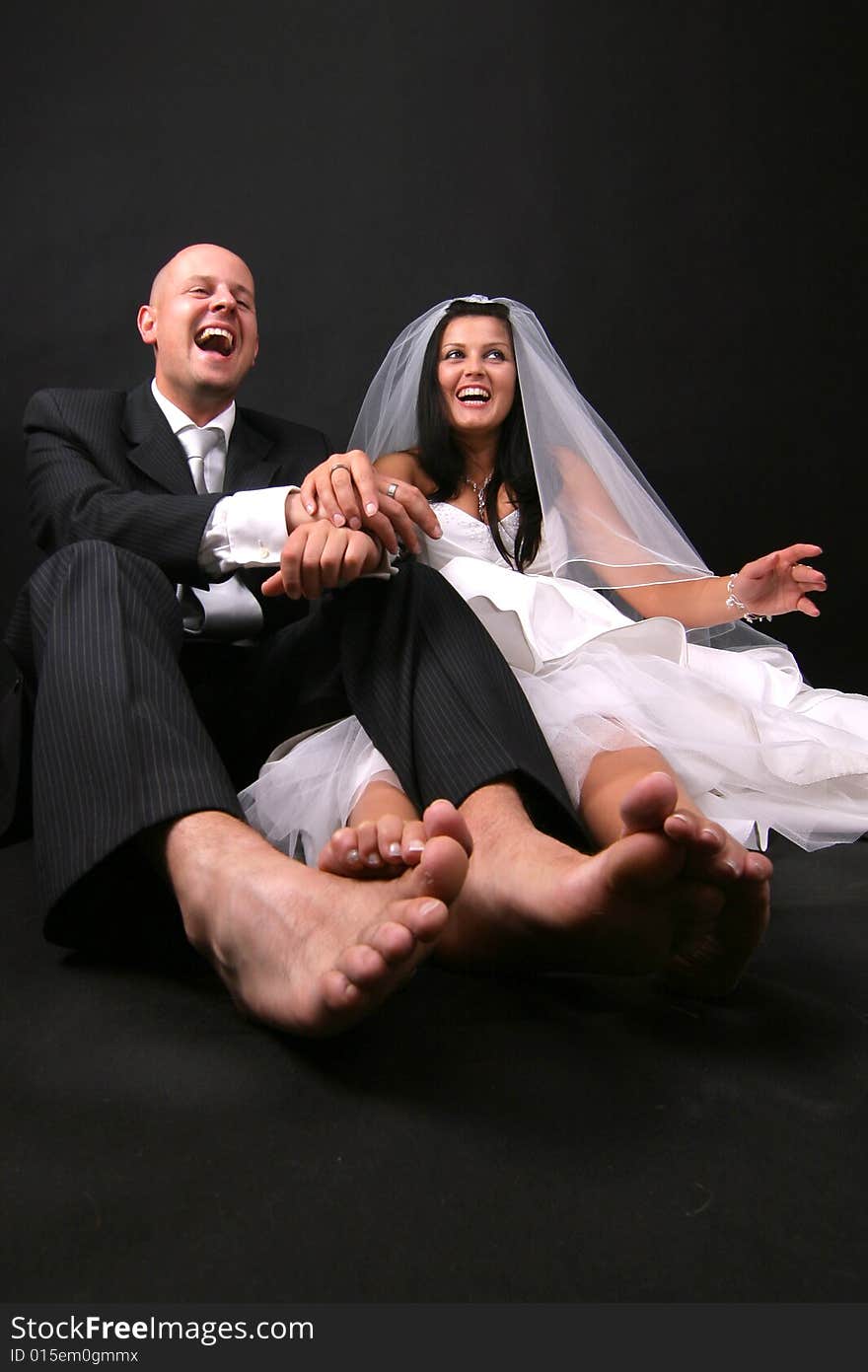 The happy newly-married couple sits on the floor