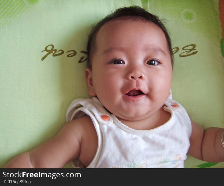 Laughing baby with her mouth opening on a pillow. Laughing baby with her mouth opening on a pillow