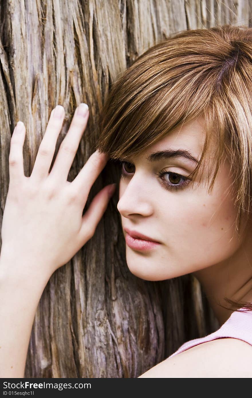 Young woman portrait over a tree trunk