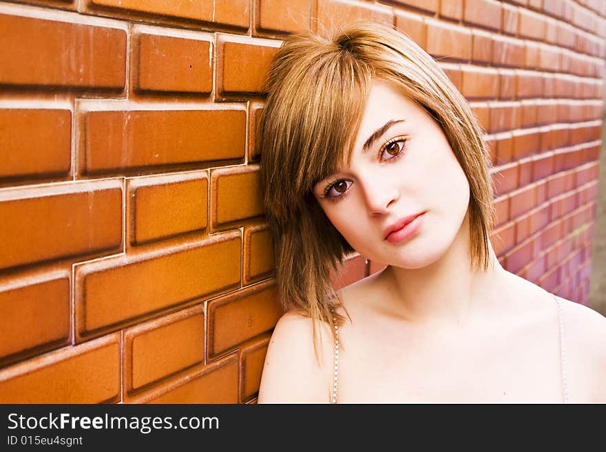 Beautiful blond woman on brick wall. Beautiful blond woman on brick wall