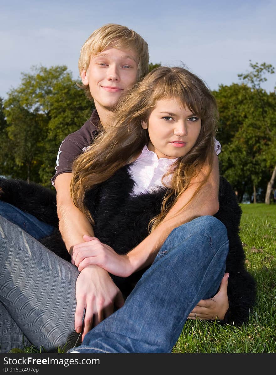 Handsome boy embracing his attractive girlfriend in the park