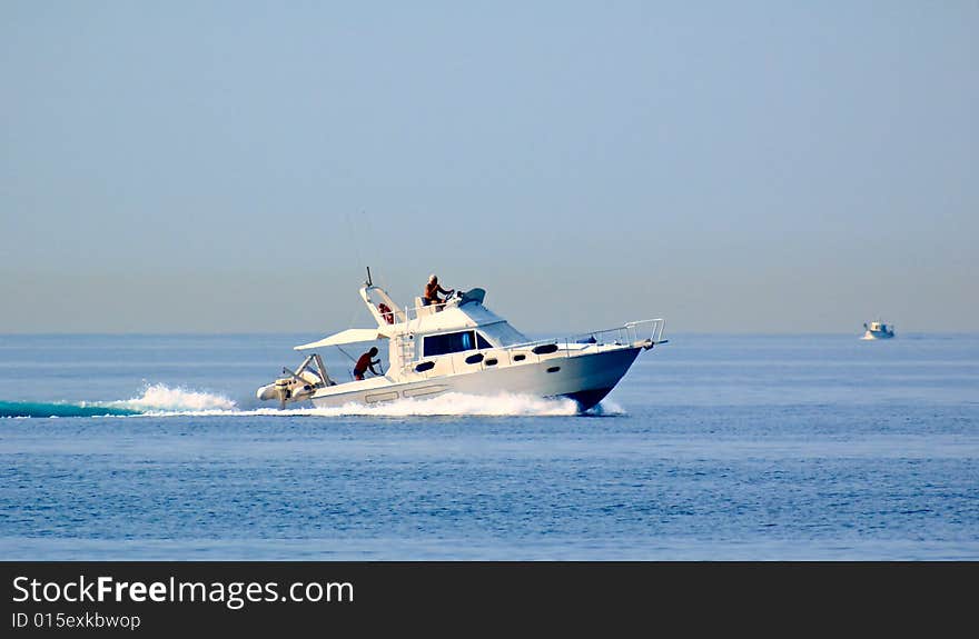 Photo of a white cutter with blue sky at the background