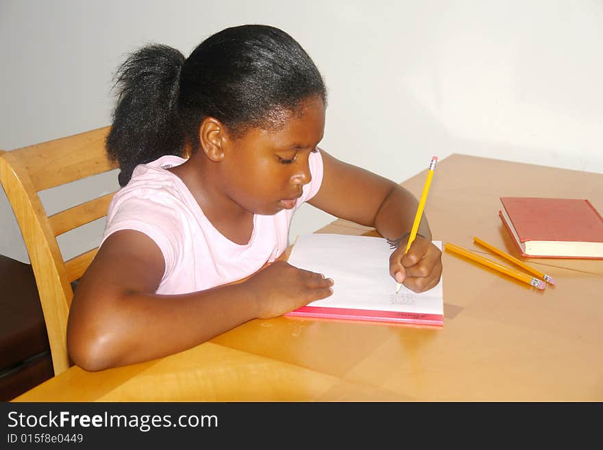 A picture of a girl student studying at kitchen table. A picture of a girl student studying at kitchen table