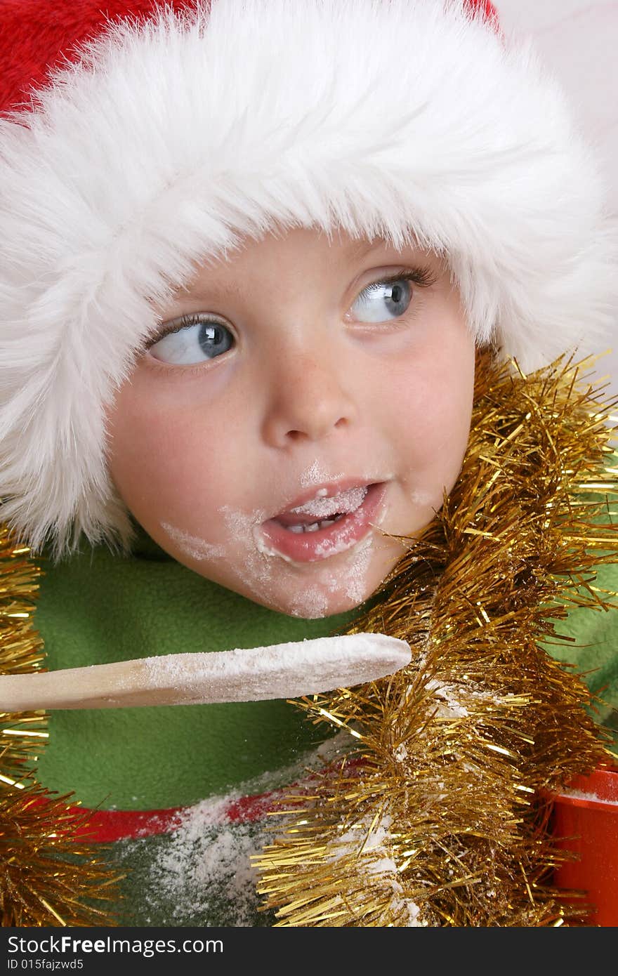 Toddler wearing a christmas hat, baking christmas cookies