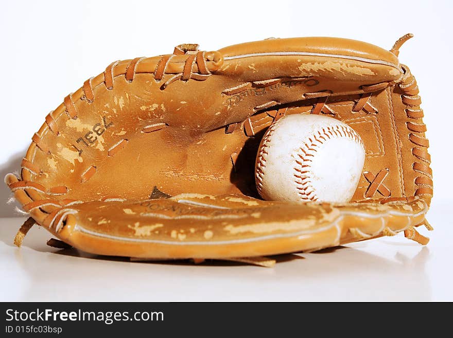 Close up of a vintage baseball mitt and baseball.