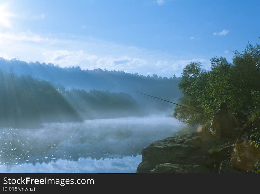 Morning landscape of misty river with sunlight rays and lonely fisherman. Morning landscape of misty river with sunlight rays and lonely fisherman