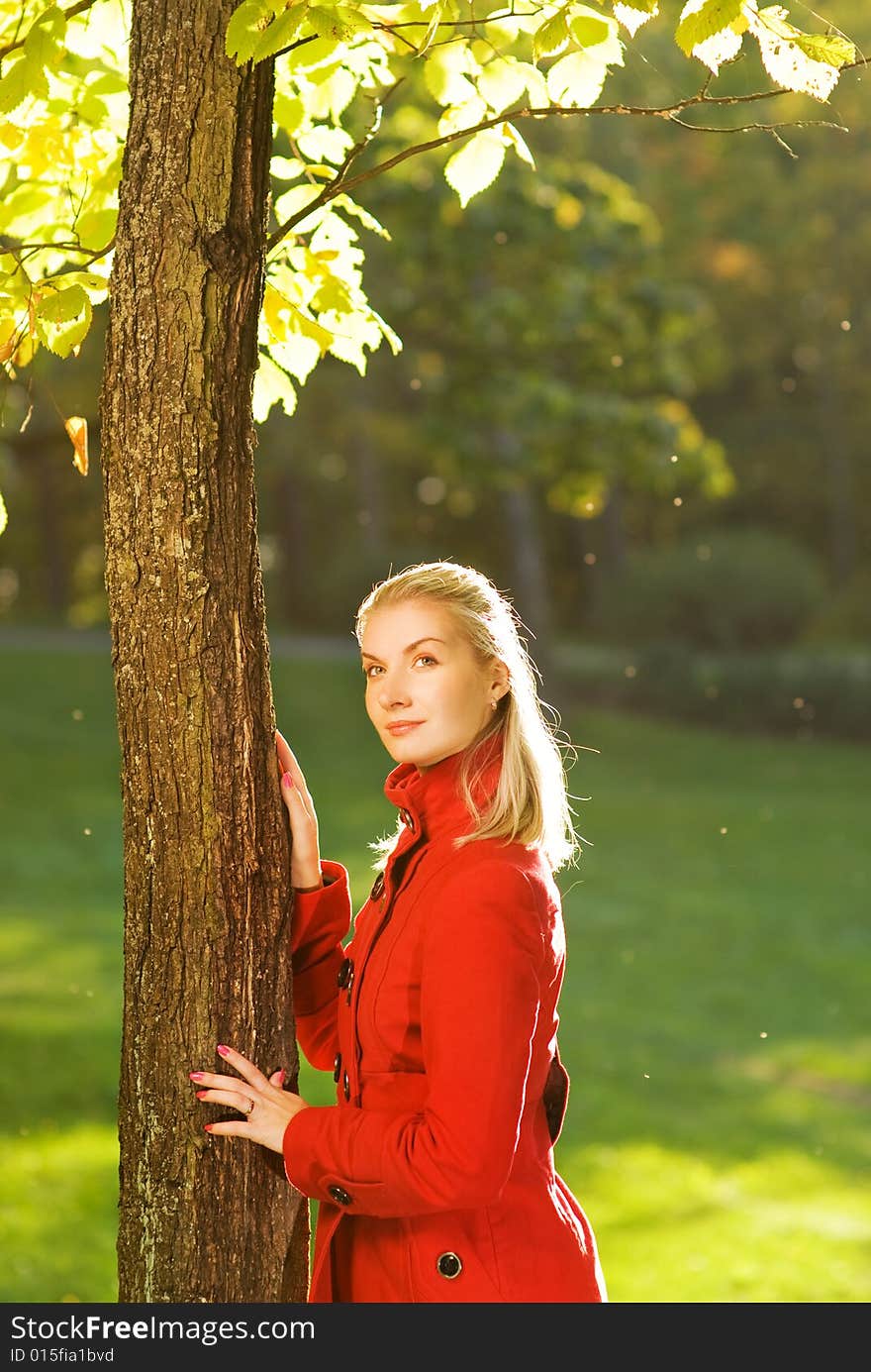 Beautiful blond woman with autumn leaves outdoors