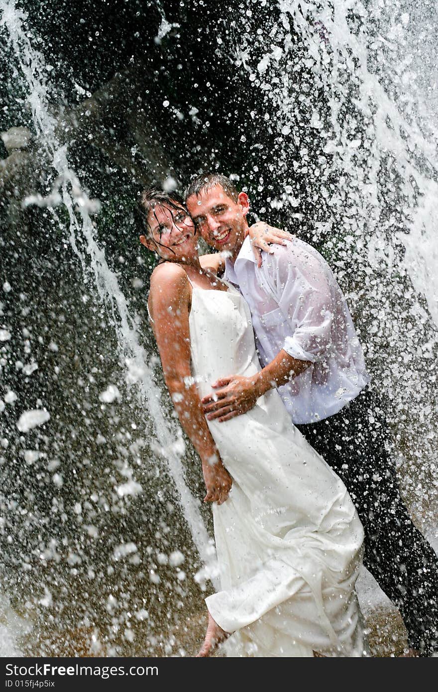 Bride and groom dancing under a water fountain on their wedding day. Bride and groom dancing under a water fountain on their wedding day.