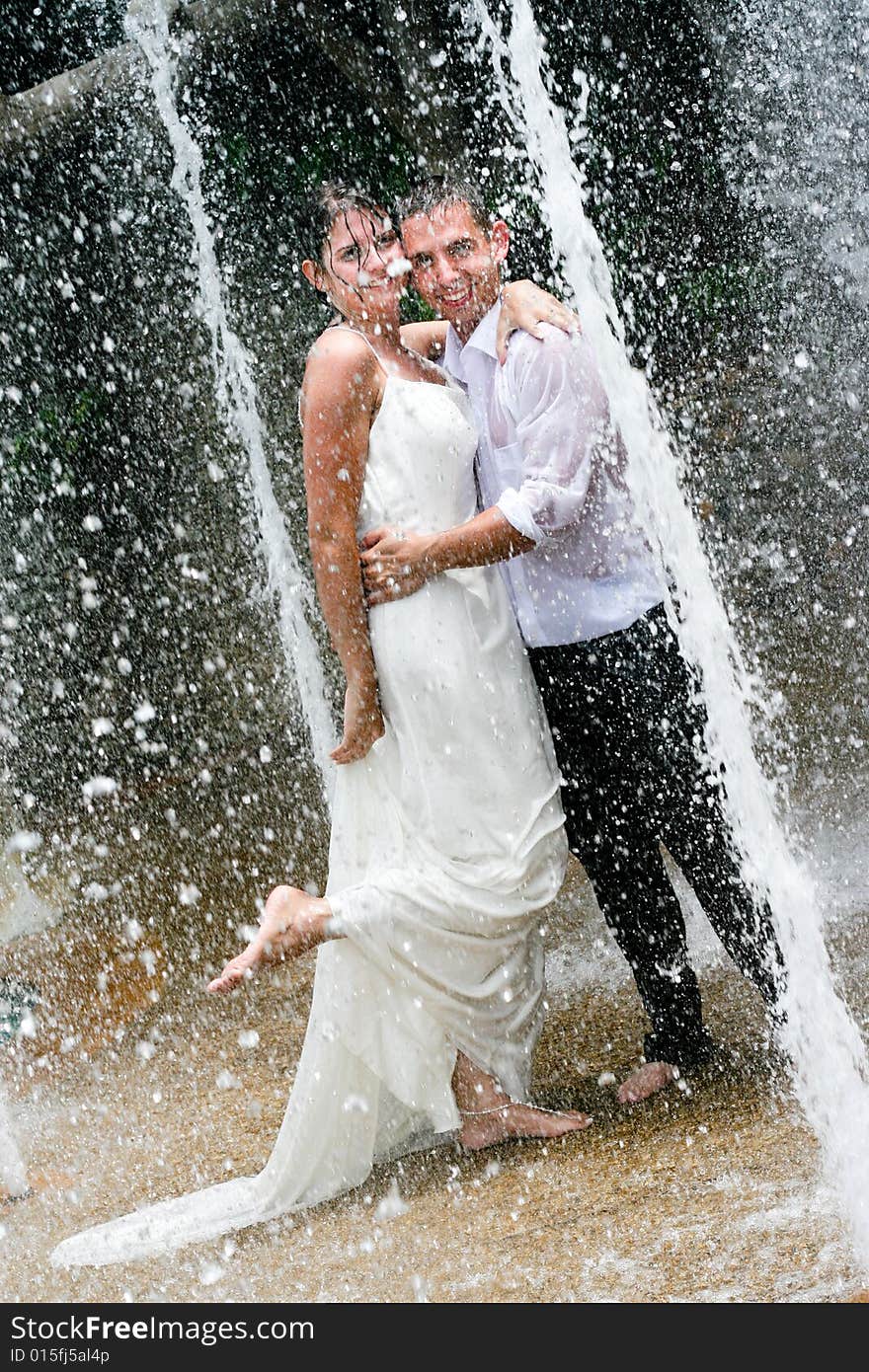 Bride and groom dancing under a water fountain on their wedding day. Bride and groom dancing under a water fountain on their wedding day.