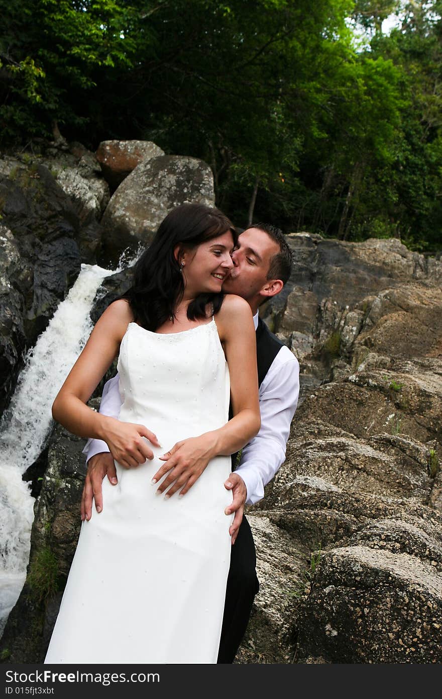 Happy bride and groom kissing on top of a mountain. Happy bride and groom kissing on top of a mountain.