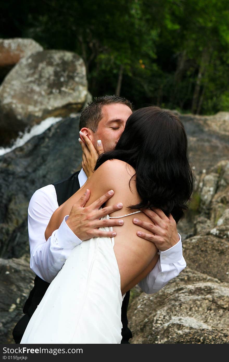 Happy bride and groom kissing on top of a mountain. Happy bride and groom kissing on top of a mountain.