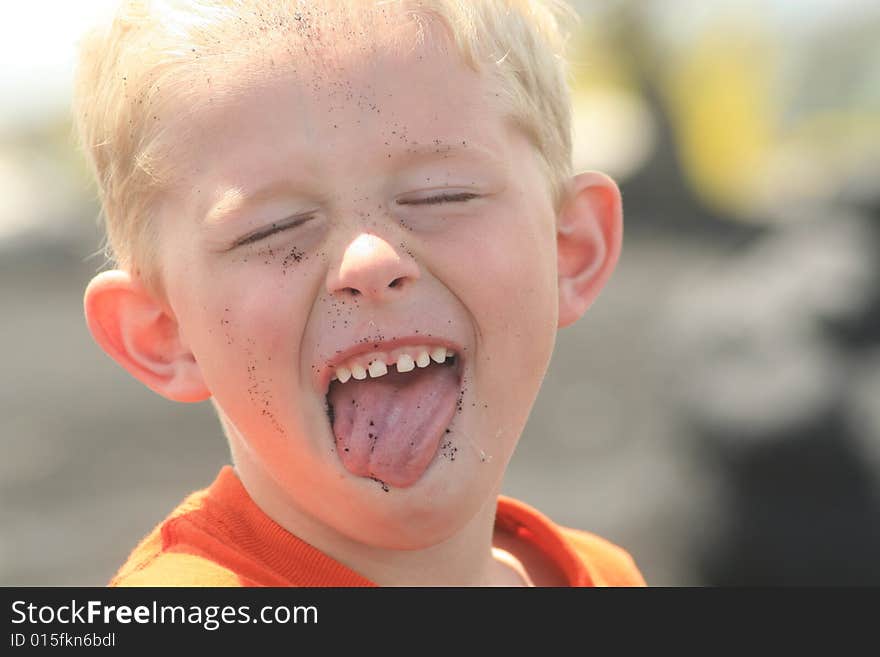 Little boy that got sand on his face and in his mouth. Little boy that got sand on his face and in his mouth