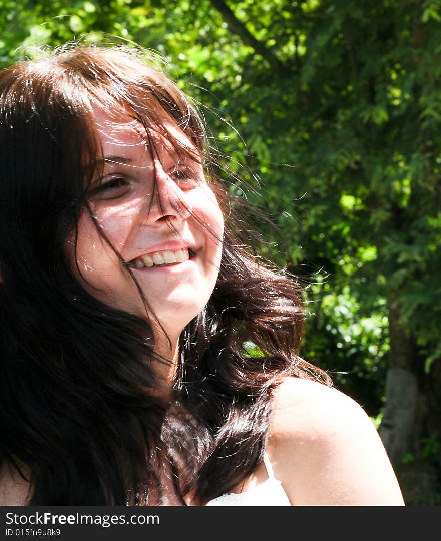 Portrait of a beautiful brunette woman with her hair blowing in the wind.