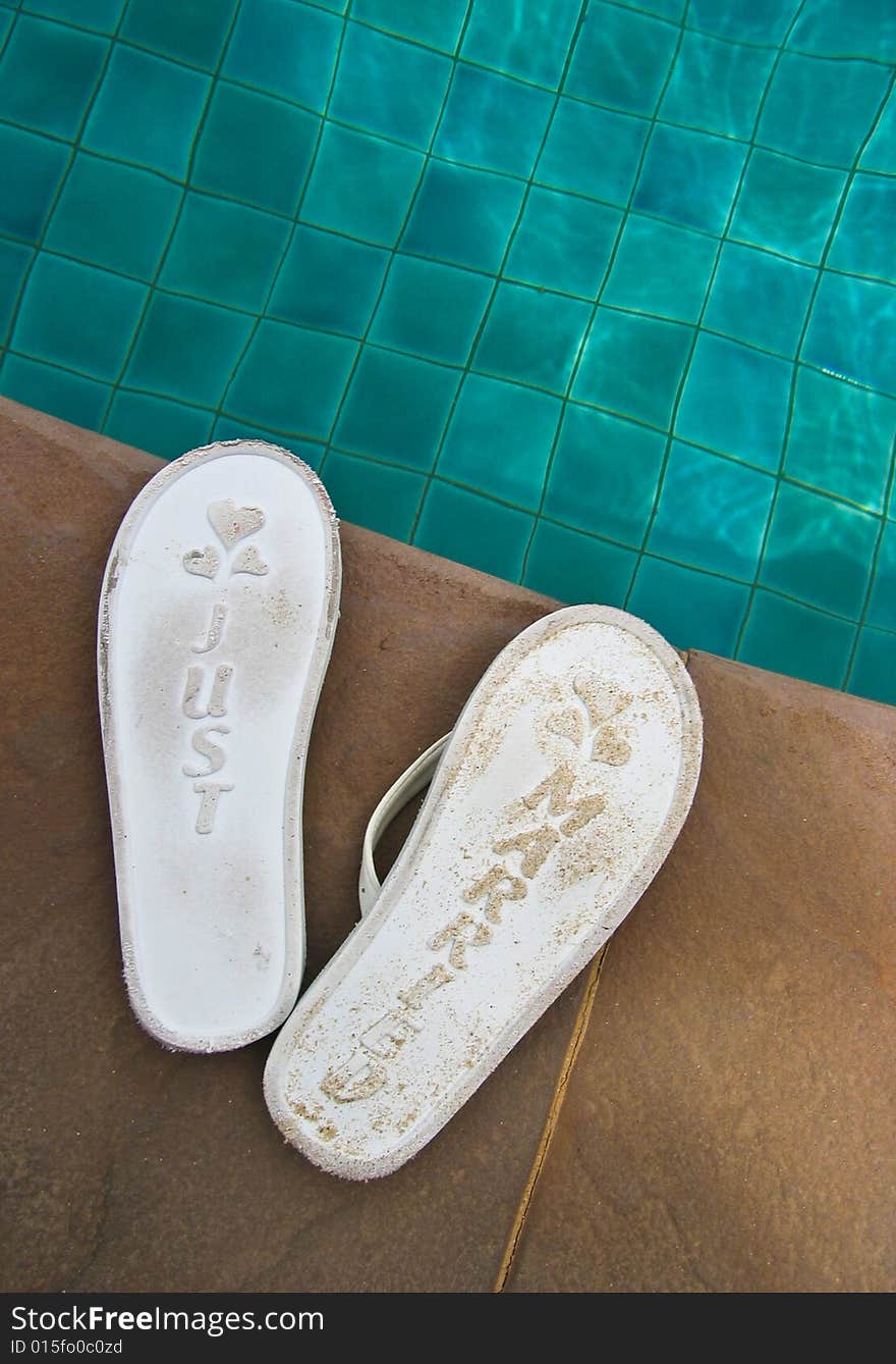 Just married flip flops at the side of a swimming pool. Just married flip flops at the side of a swimming pool.