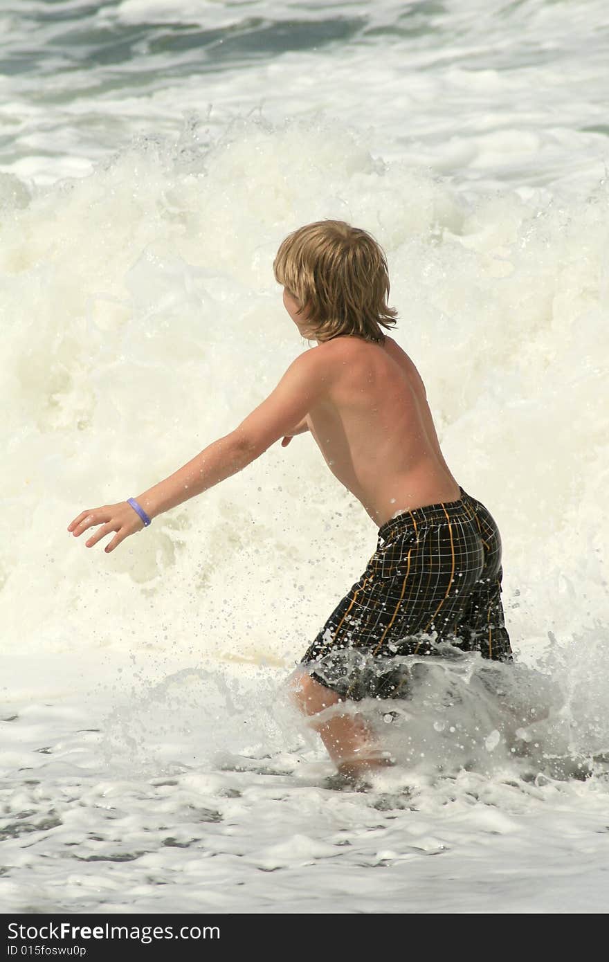 Young boy trying to run from the powerful waves. Young boy trying to run from the powerful waves