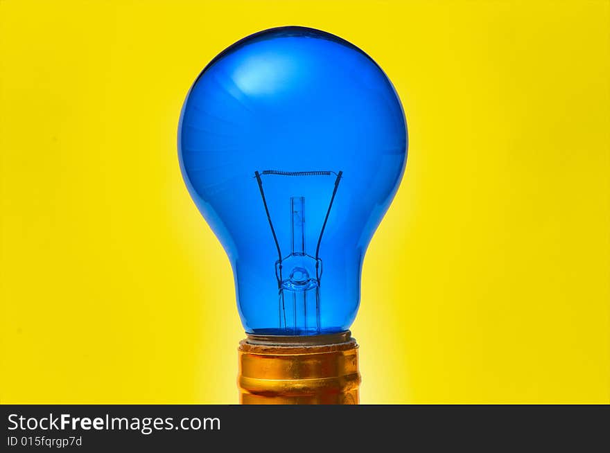 Blue light bulb isolated over yellow background