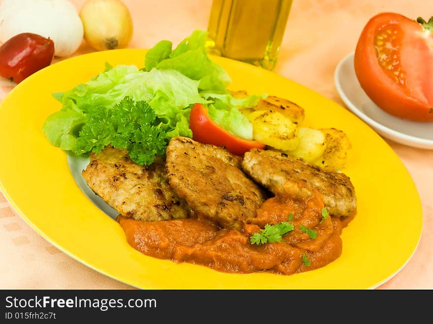 Baked hamburger with tomato sauce,fried potatoes ,salad.