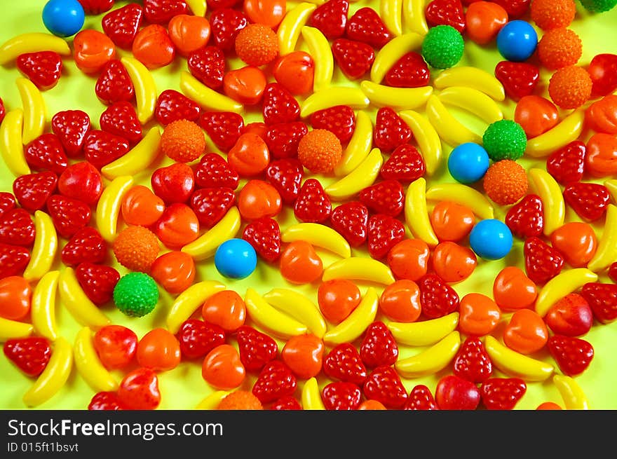 Colorful fruit candy on yellow background