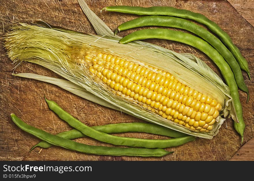 Green beans and corn on wooden table. Green beans and corn on wooden table