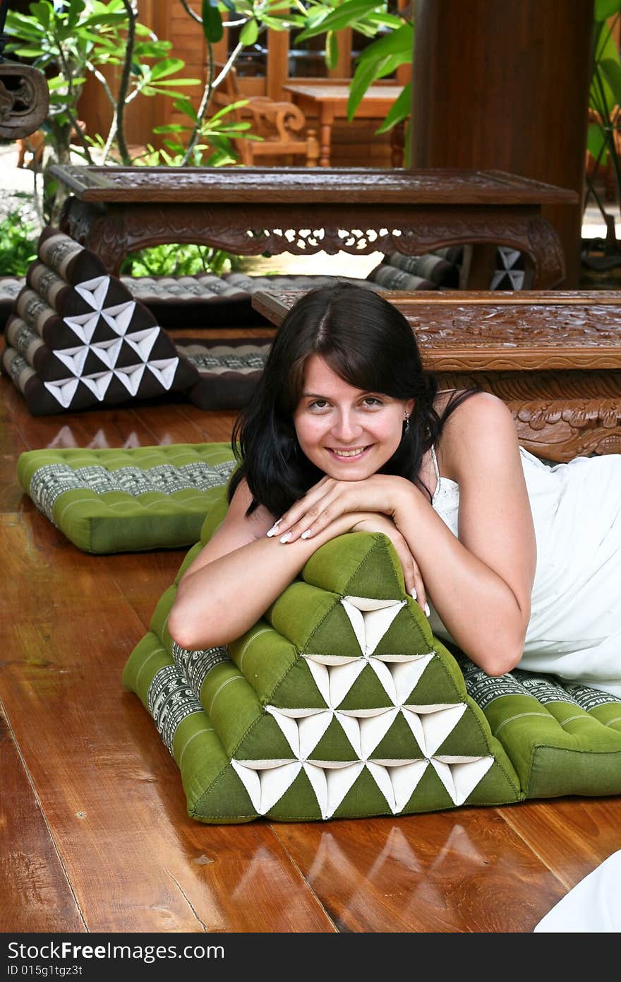 Beautiful young bride relaxing on a Thai cushion.