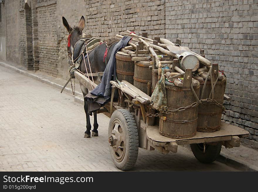 A donkey car with some barrels.