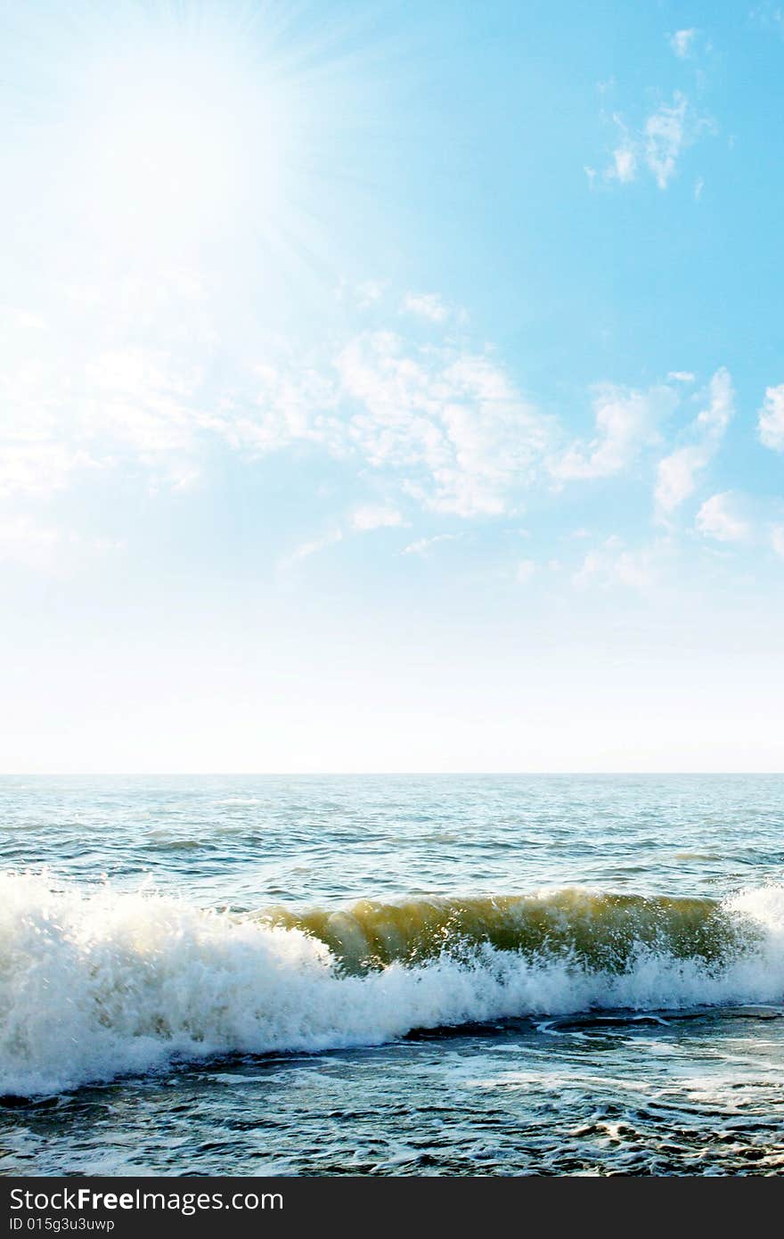 Bright sunbeams illuminate beautiful sea beachWave on sea beach under year blue sky and cloud