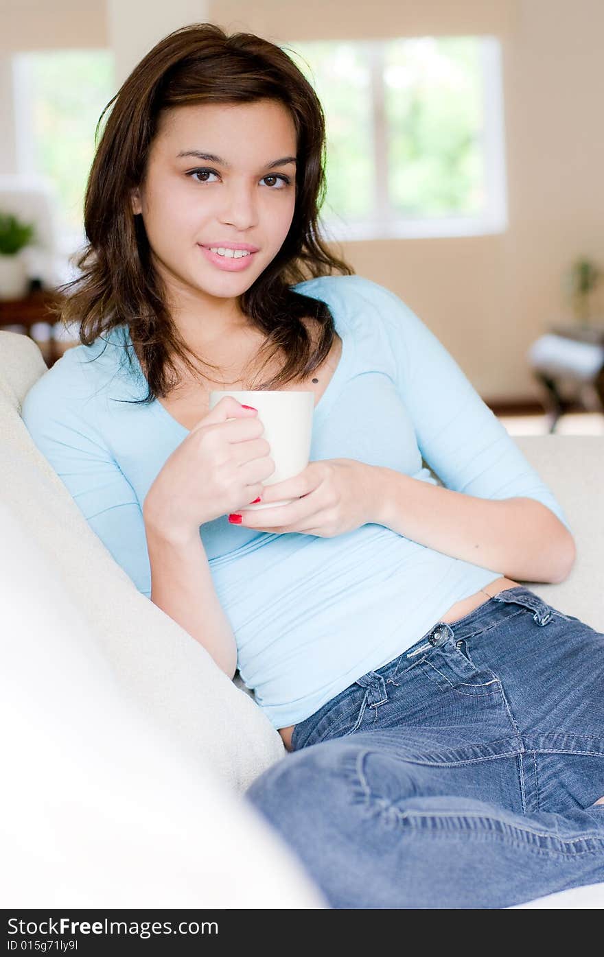 An attractive young woman drinking coffee at home. An attractive young woman drinking coffee at home