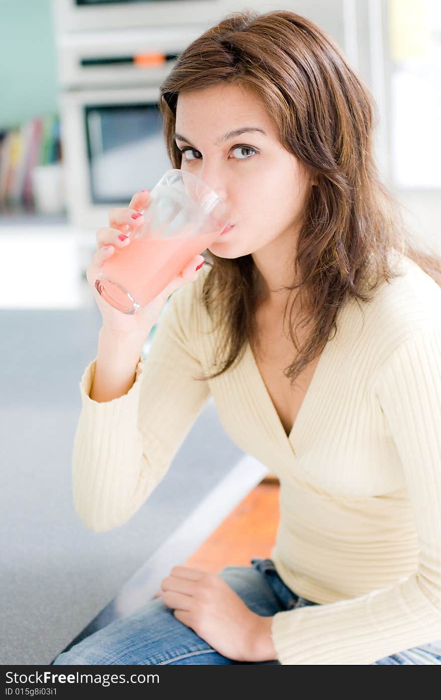 A beautiful young woman drinking grapefruit juice. A beautiful young woman drinking grapefruit juice