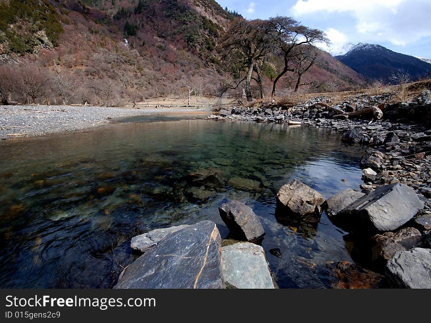 Plateau on the river, the water is very clear, is far from tall trees and dry.Photographs the place is the Chinese Sichuan province Xiaojin County's Mt. Siguniang mountain