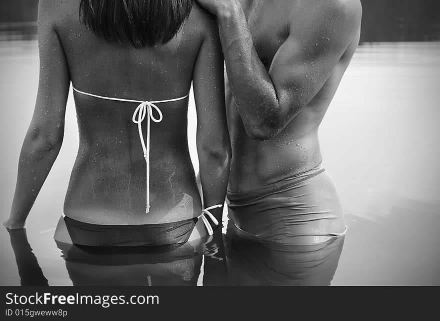 A man embraces a woman standing in the water / black and white photo. A man embraces a woman standing in the water / black and white photo